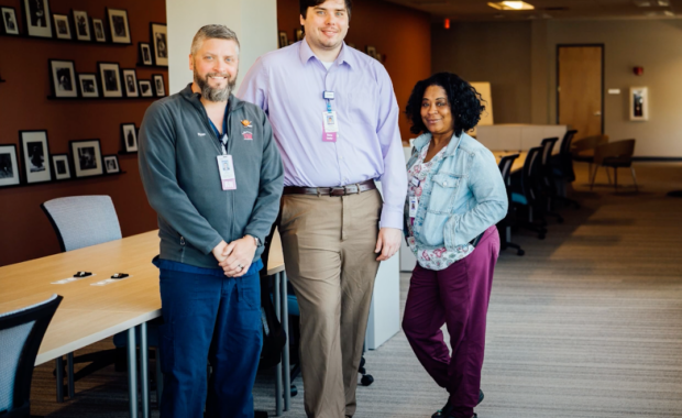 Medical respite requires cross-sector collaborations. Three colleagues stand together smiling in the Buffalo Recuperative Care unit.